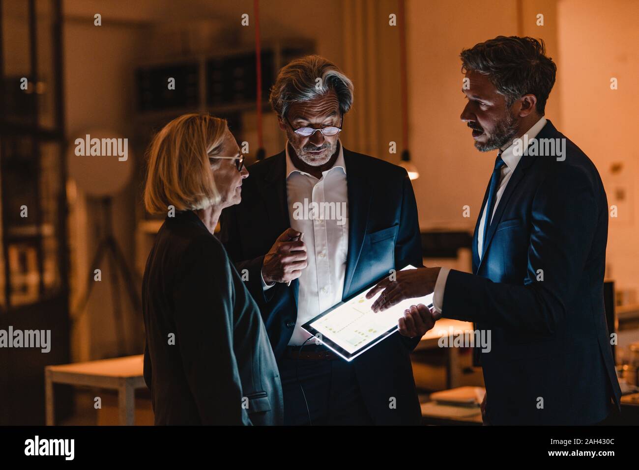 Business people with shining tablet talking in office Stock Photo