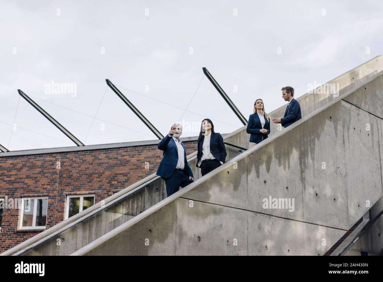 Business people standing on exterior stair Stock Photo