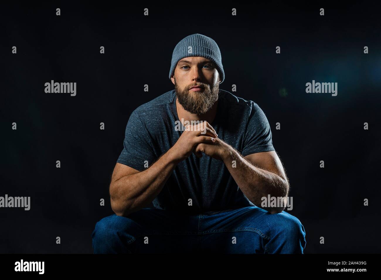 Portrait of a muscular man sitting in studio Stock Photo