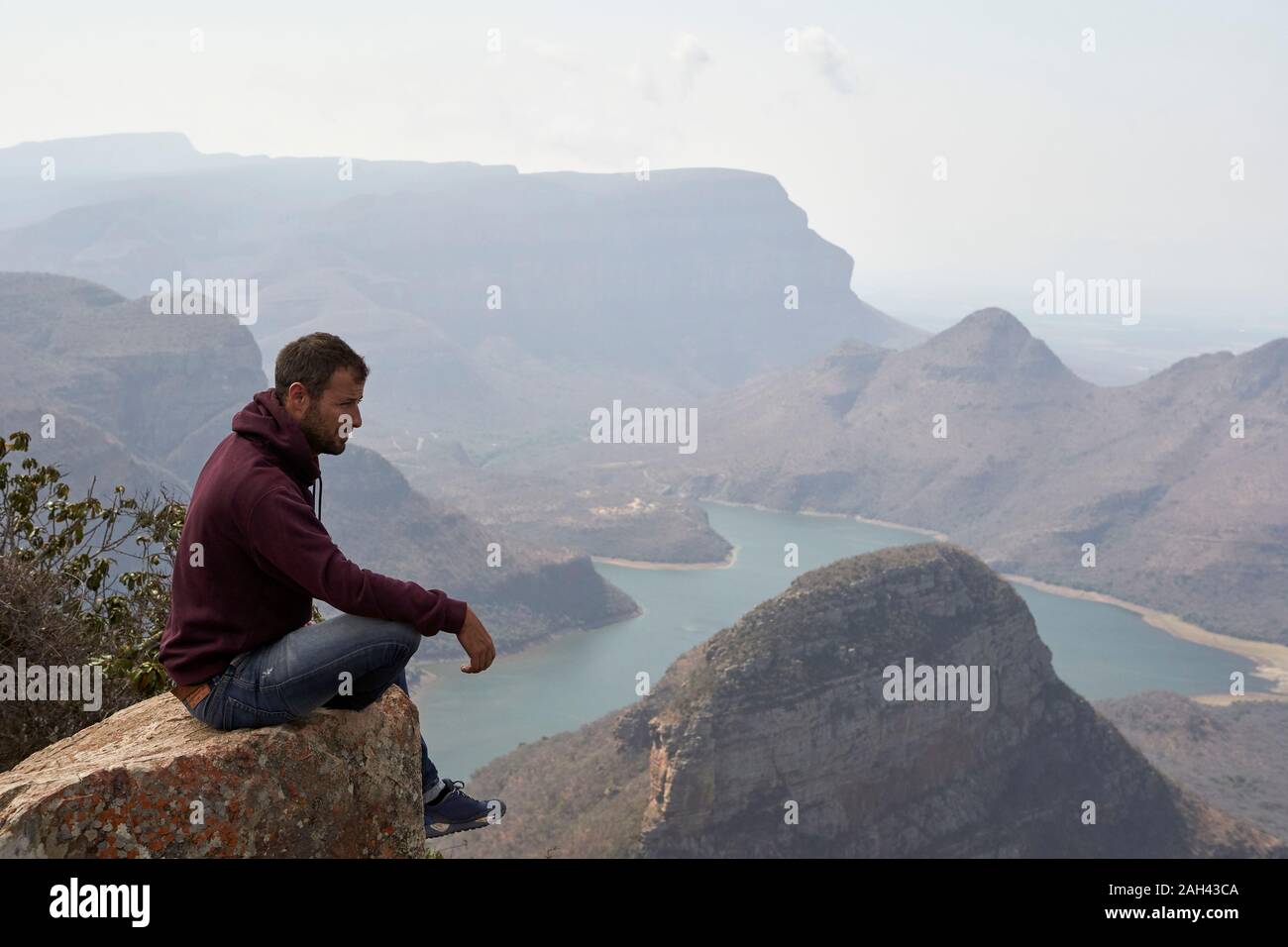 Man sitting on a rock with beautiful landscape as background, Blyde River Canyon, South Africa Stock Photo