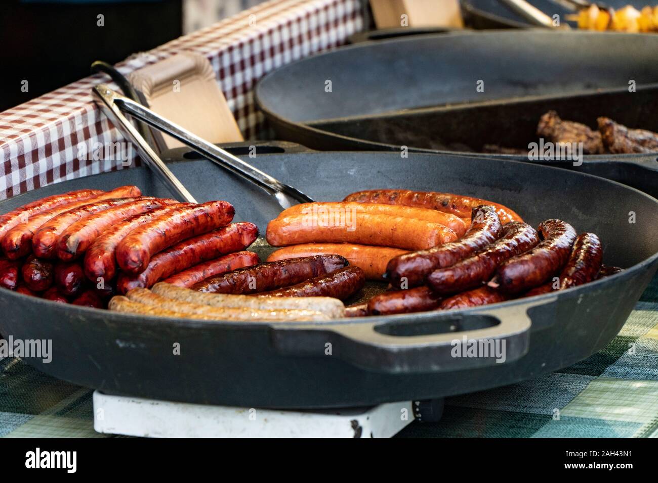Prague, Czech Republic 2019:Traditional hot dog preparation on coal fire on the street during the Christmas market Stock Photo