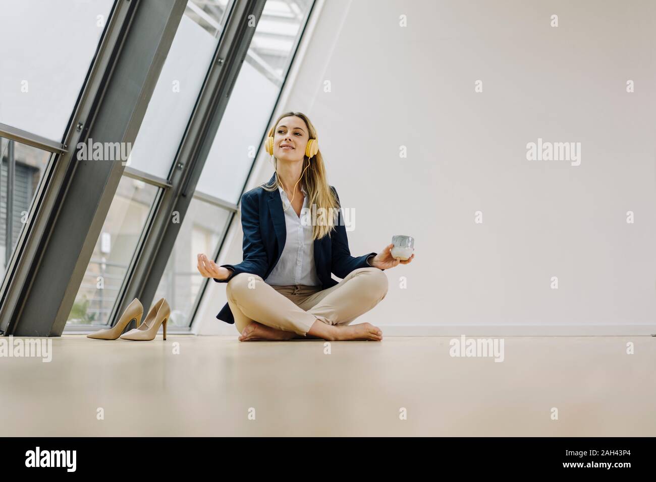 Young businesswoman practicing yoga in office Stock Photo