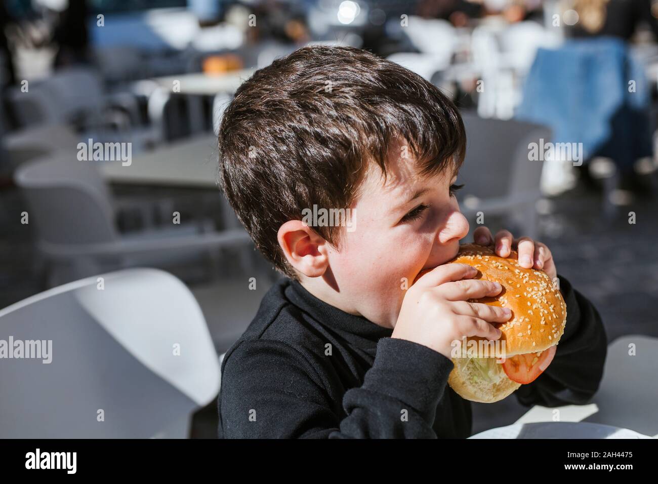 Little boy eating a hamburger Stock Photo