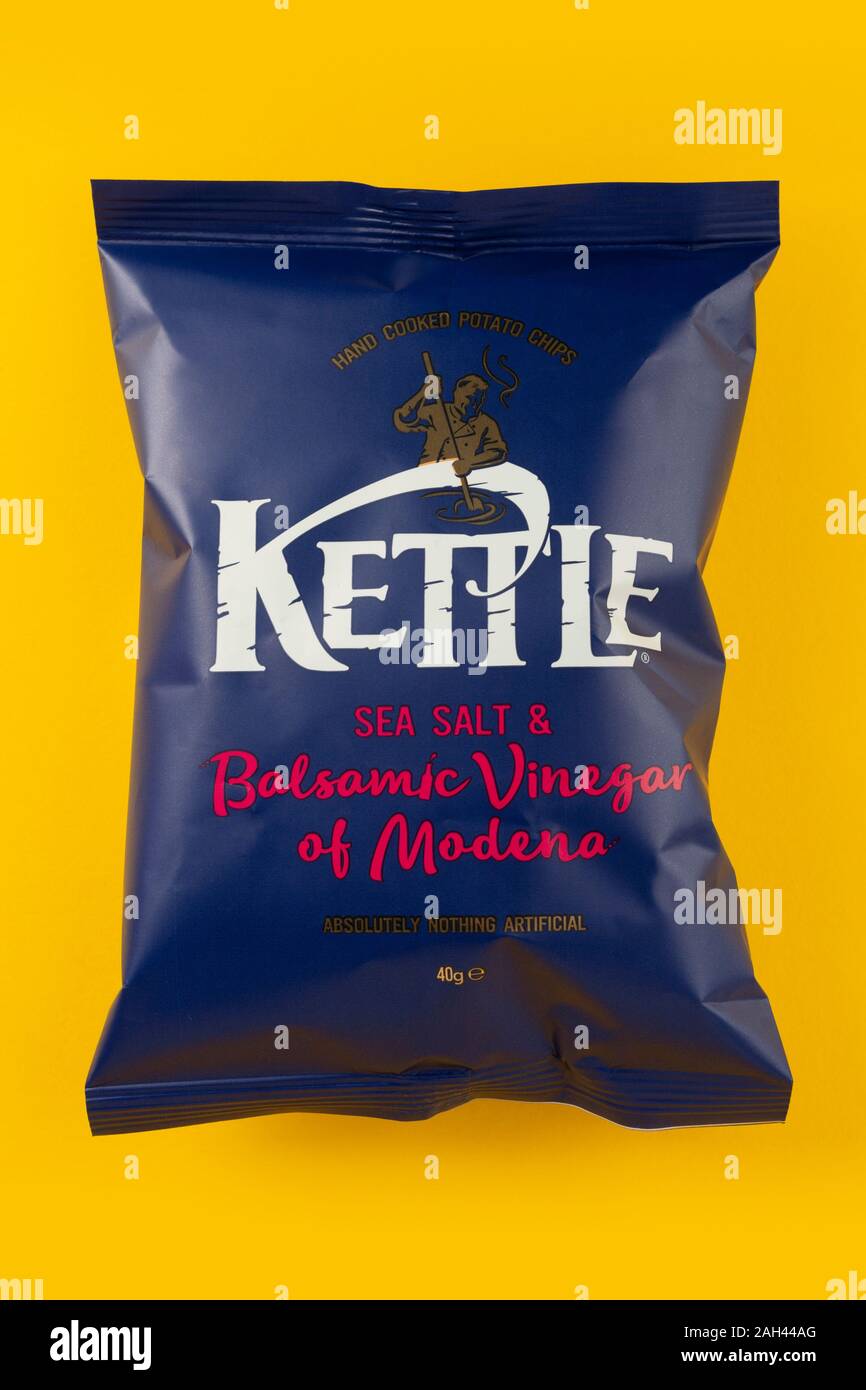 A packet of Kettle sea salt and balsamic vinegar of Modena crisps shot on a yellow background. Stock Photo