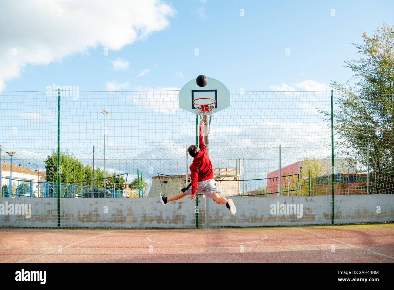 Teenager playing basketball, dunking Stock Photo