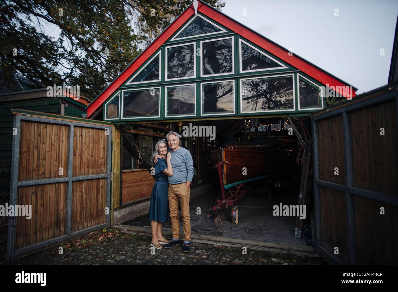 Senior couple standing in front of boathouse Stock Photo