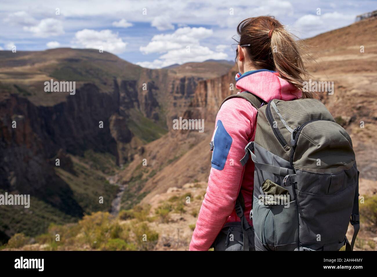 Woman standing on top of a hill at Maletsunyane Falls enjoying the view, Lesotho Stock Photo