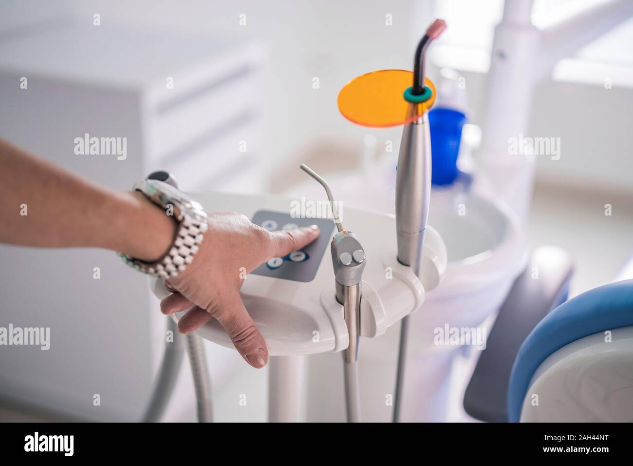 Hand pressing button of dental instrument in dental clinic Stock Photo
