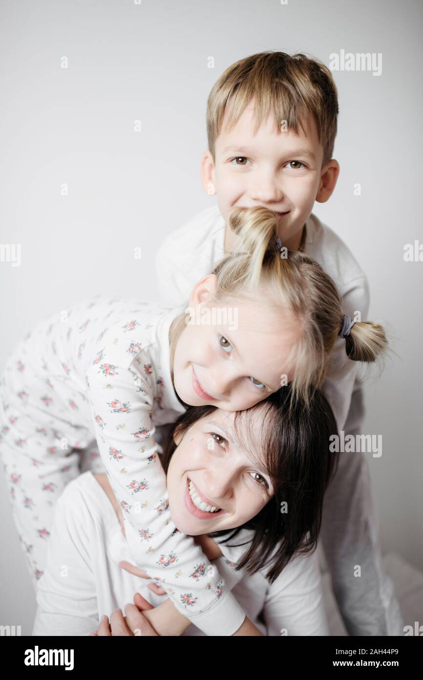 Mother having fun time with two kids on bed Stock Photo