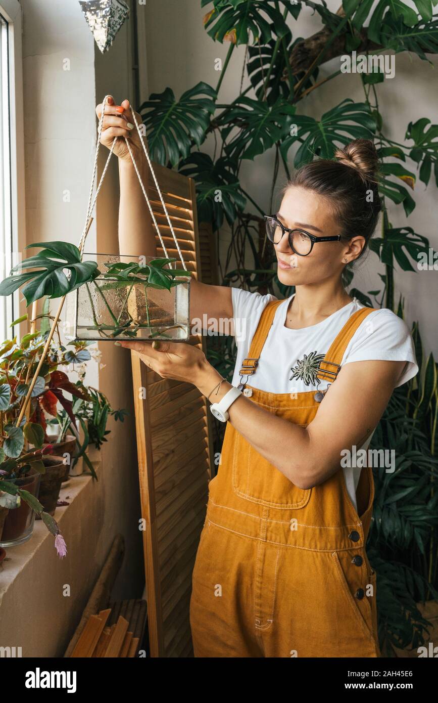 Young woman holding plant in a box with water Stock Photo