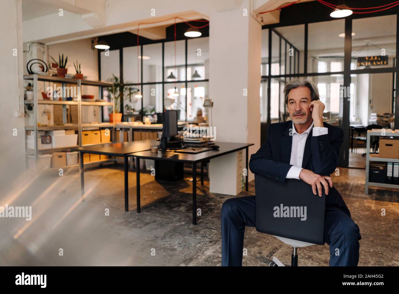 Senior businessman sitting on chair in office Stock Photo - Alamy