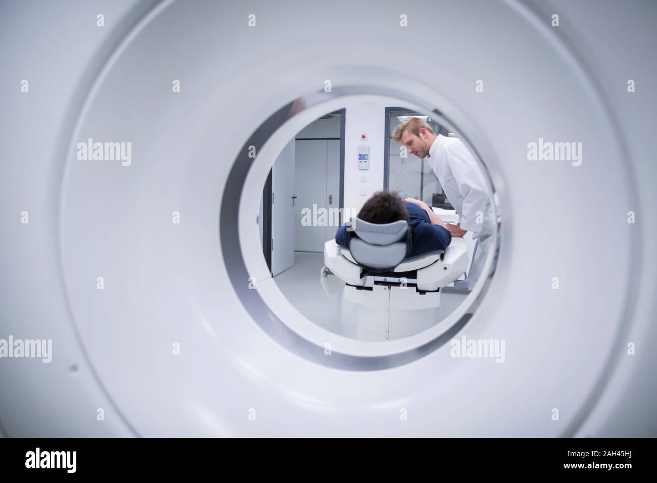 Patient in hospital during CT examination and radiologist Stock Photo