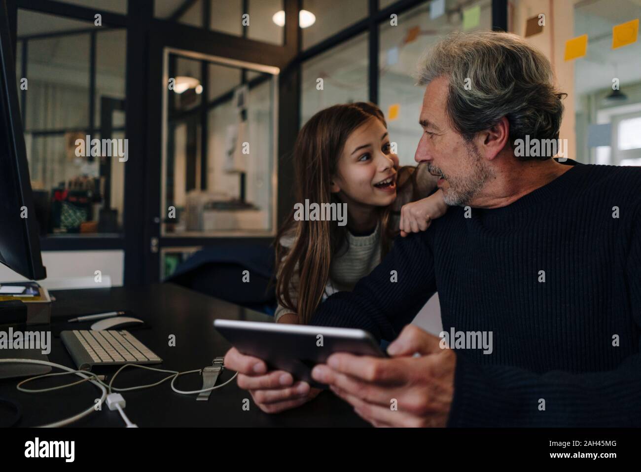 Casual senior buisinessman and girl with tablet in office Stock Photo