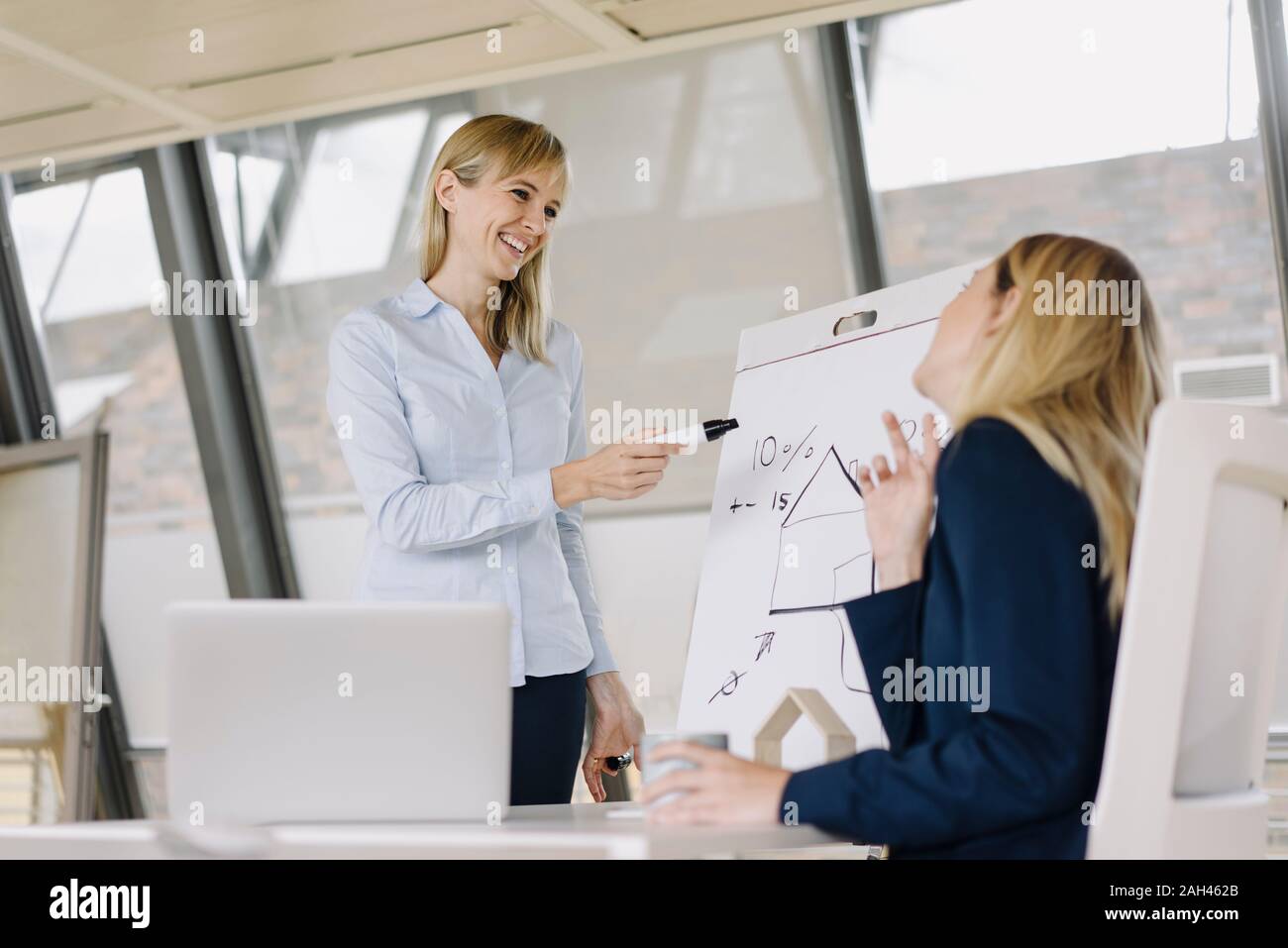 Two young businesswomen working with flip chart in office Stock Photo