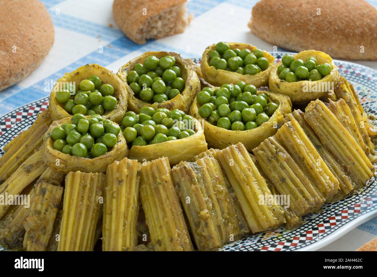 Moroccan dish with Cardoon, stuffed artichoke hearts with green peas and pieces of bread around close up Stock Photo