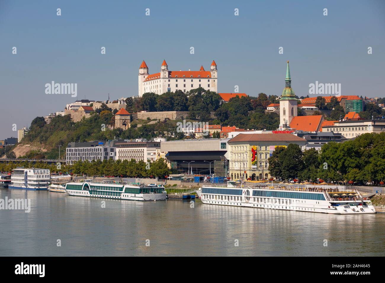Slovakia, Bratislava, Cruise ships moored on Danube river and Bratislava Castle Stock Photo