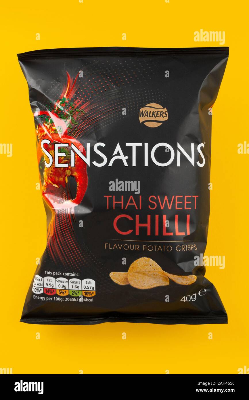 A packet of Walkers Sensations crisps shot on a yellow background. Stock Photo