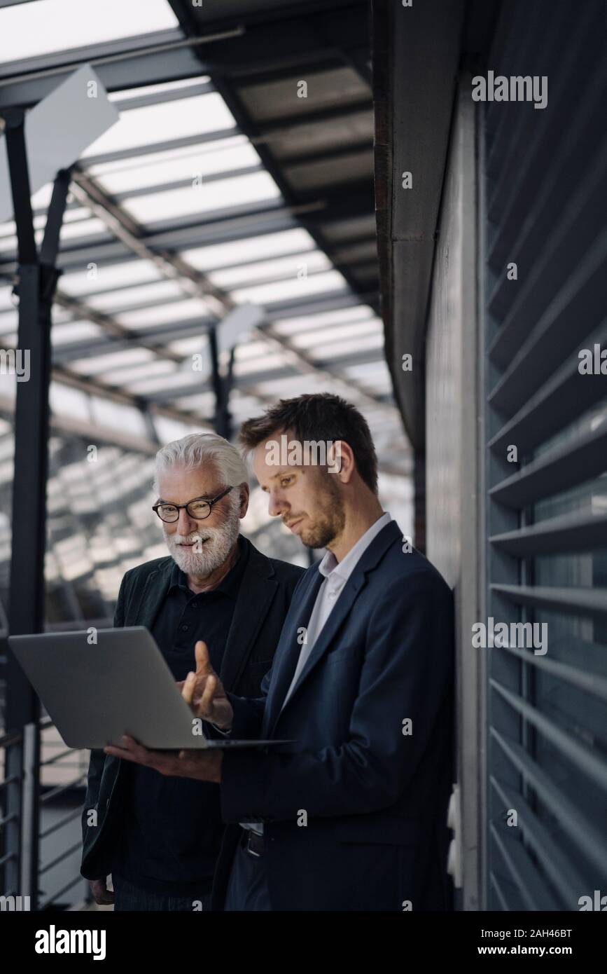 Two businessmen using laptop in office together Stock Photo