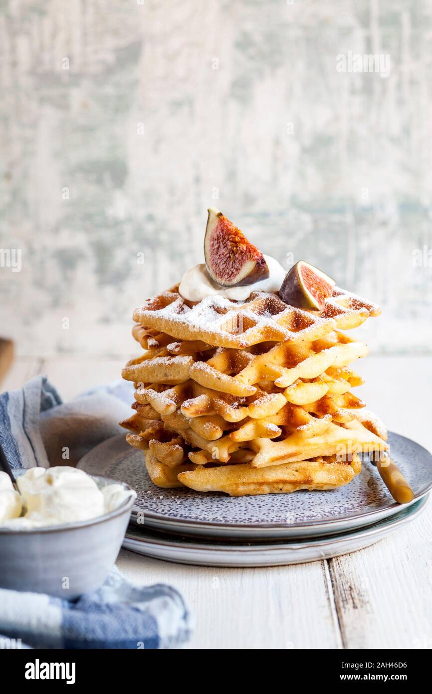 Plate of thick Belgian waffles with whipped cream, powdered sugar and figs Stock Photo