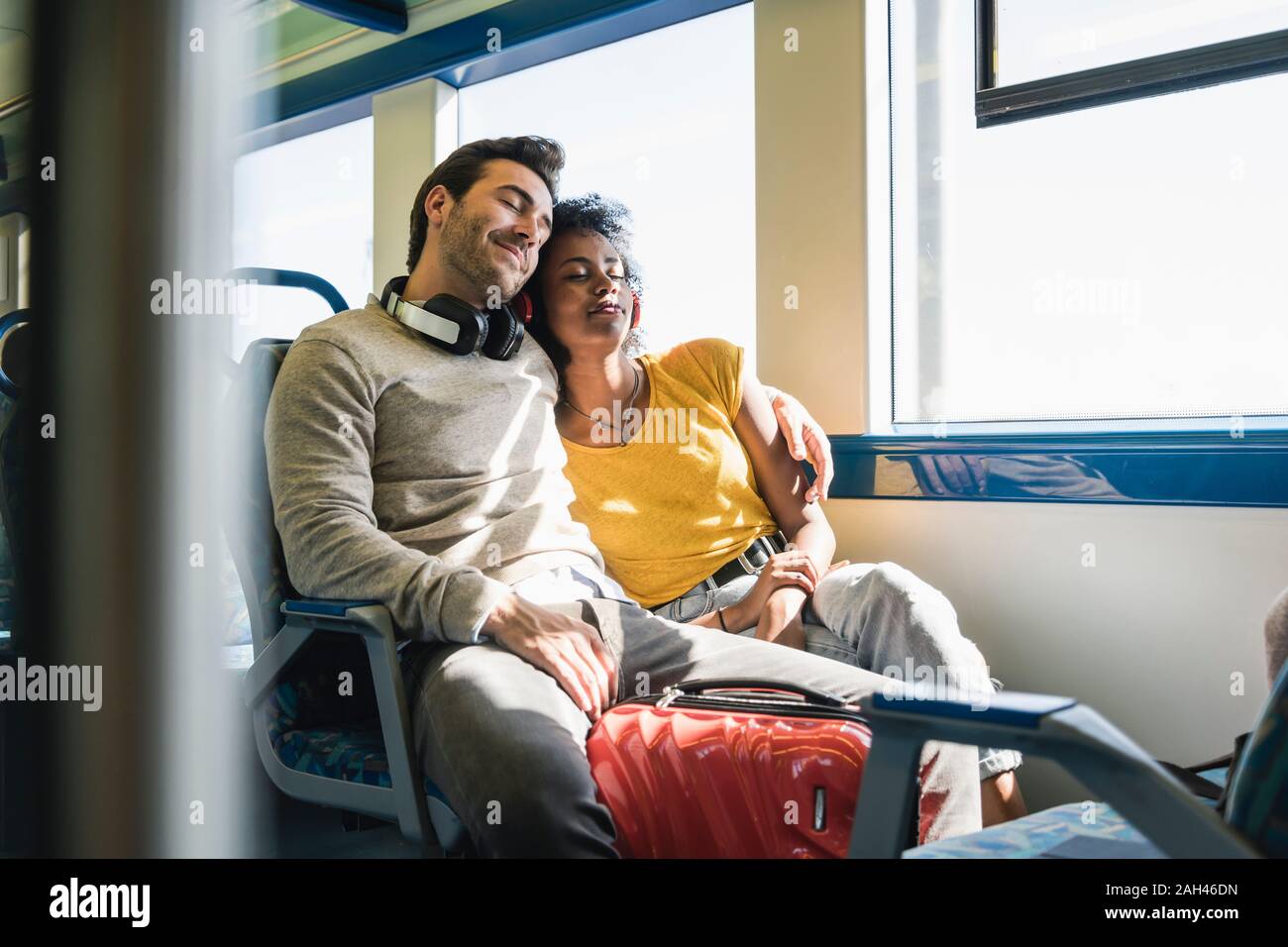 Young couple with closed eyes relaxing in a train Stock Photo