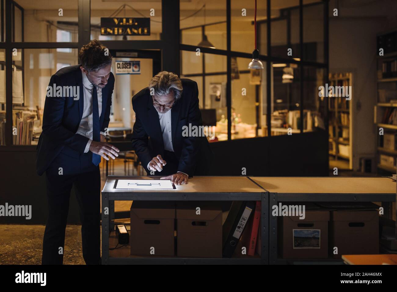 Two businesssmen with shining tablet talking in office Stock Photo