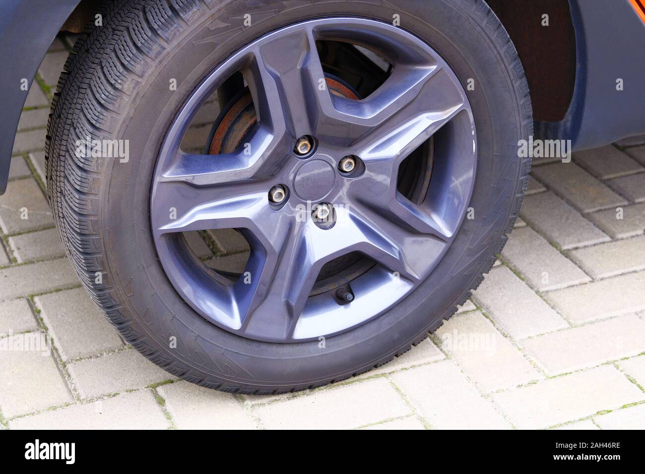 Car wheel, close up. Auto is parked in its parking spot in city Stock