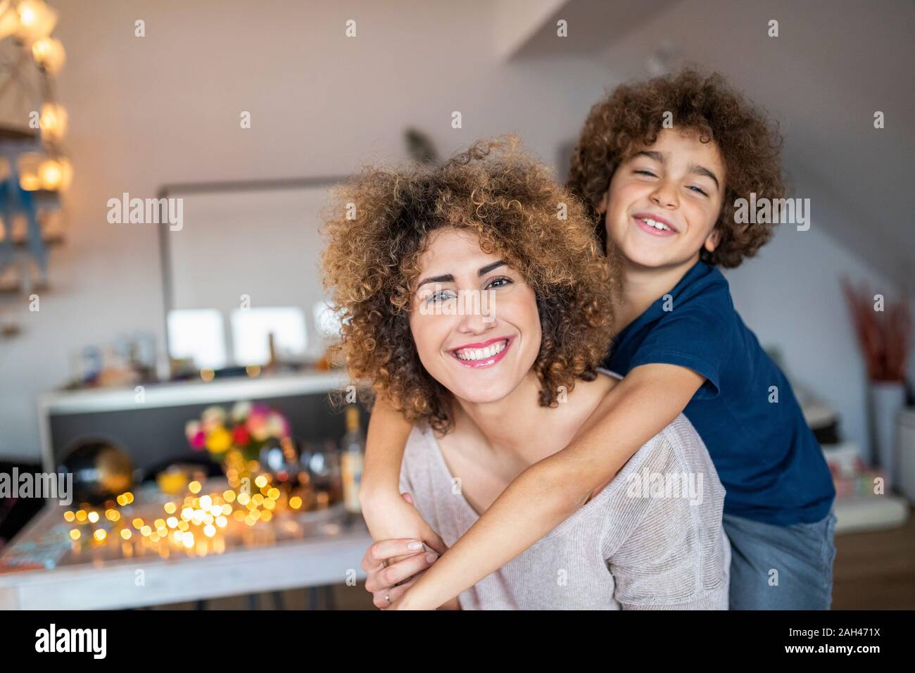 Mother with son, piggyback at home Stock Photo