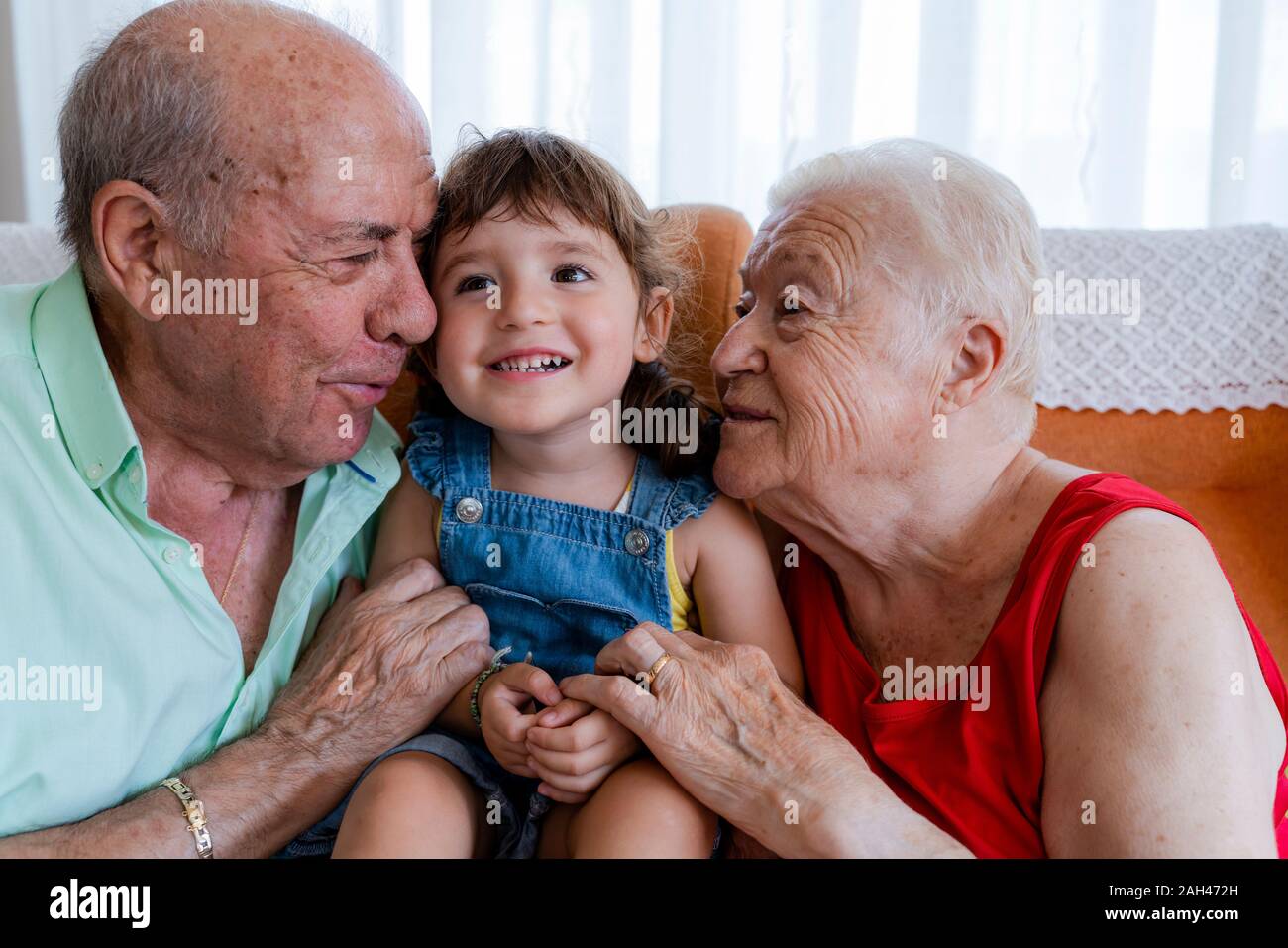 Happy grandparents with little girl at home Stock Photo