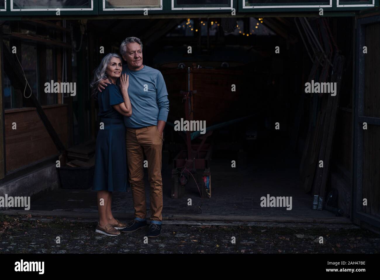 Senior couple standing in front of boathouse Stock Photo