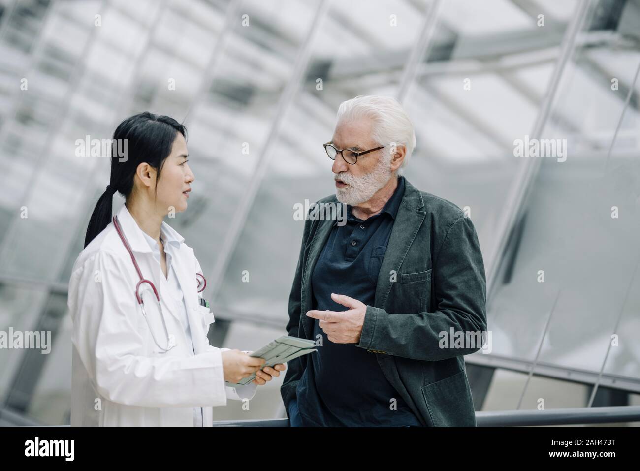 Female doctor talking to senior man Stock Photo