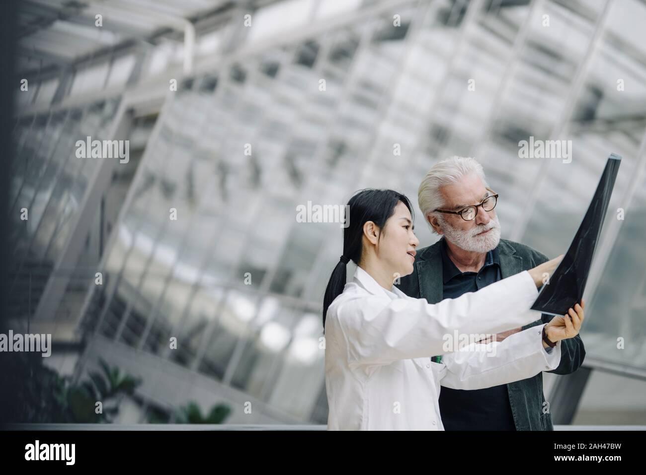 Female doctor discussing x-ray with senior patient Stock Photo
