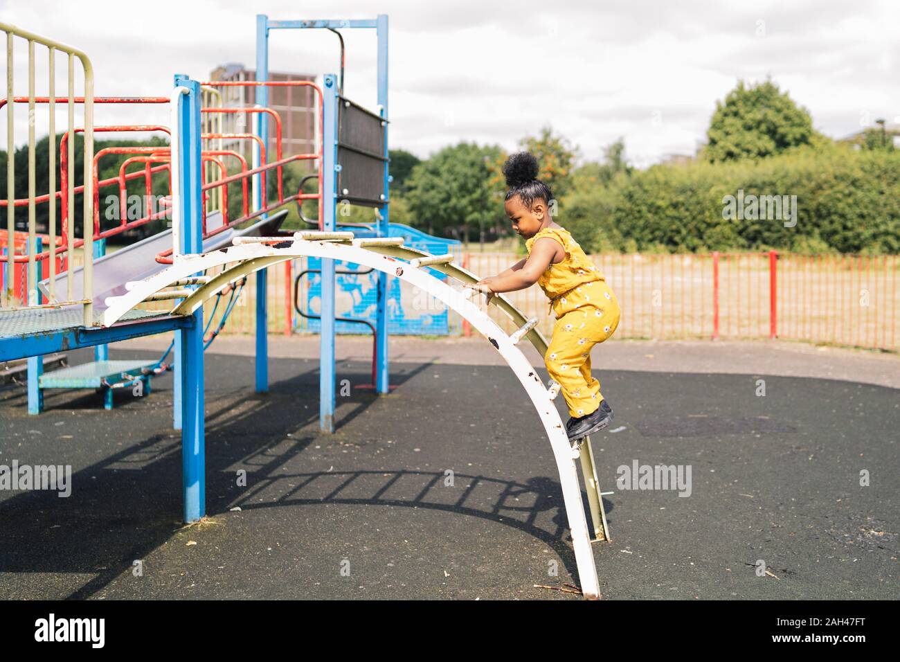 Girl climbing up a ladder on a playground Stock Photo Alamy