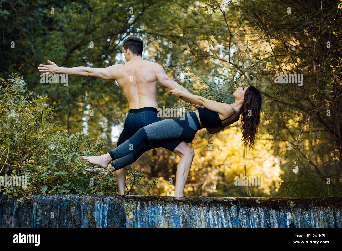 Two athletes performing duo acroyoga poses Stock Photo by Photology75