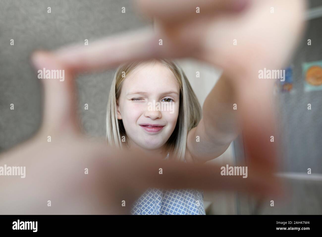 Portrait of girl at home making a finger fame Stock Photo