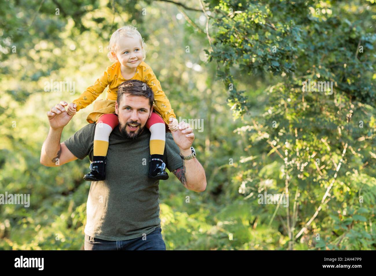 Mature man playing with his little daughter in nature Stock Photo