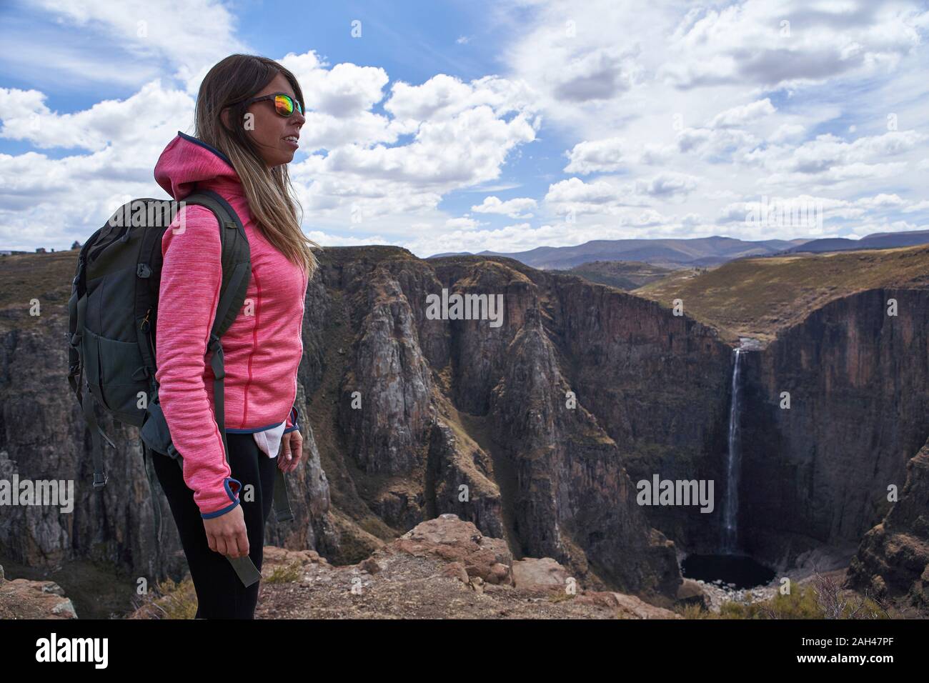 Woman standing on top of a hill at Maletsunyane Falls enjoying the view, Lesotho Stock Photo
