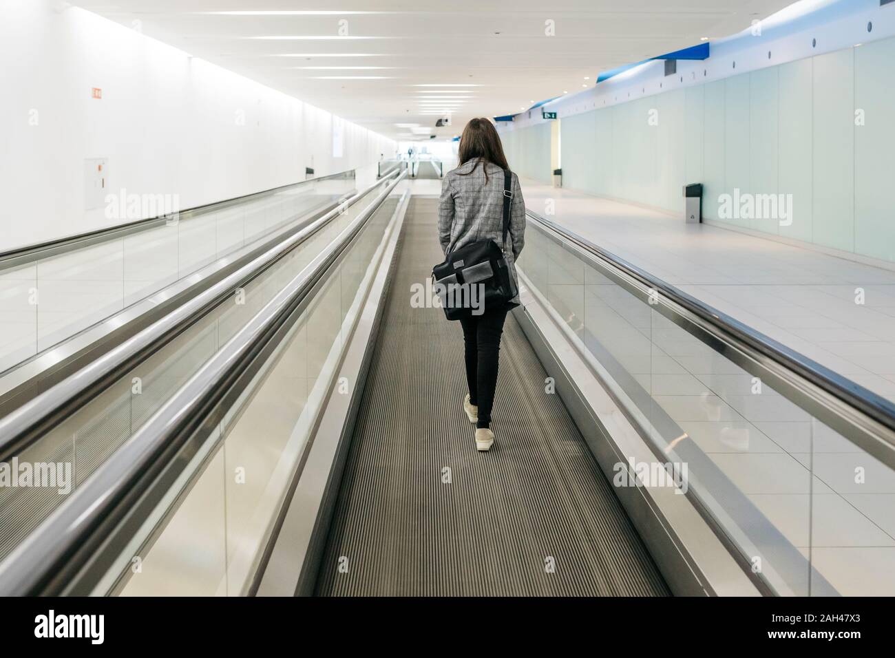 Young businesswoman on moving walkway Stock Photo