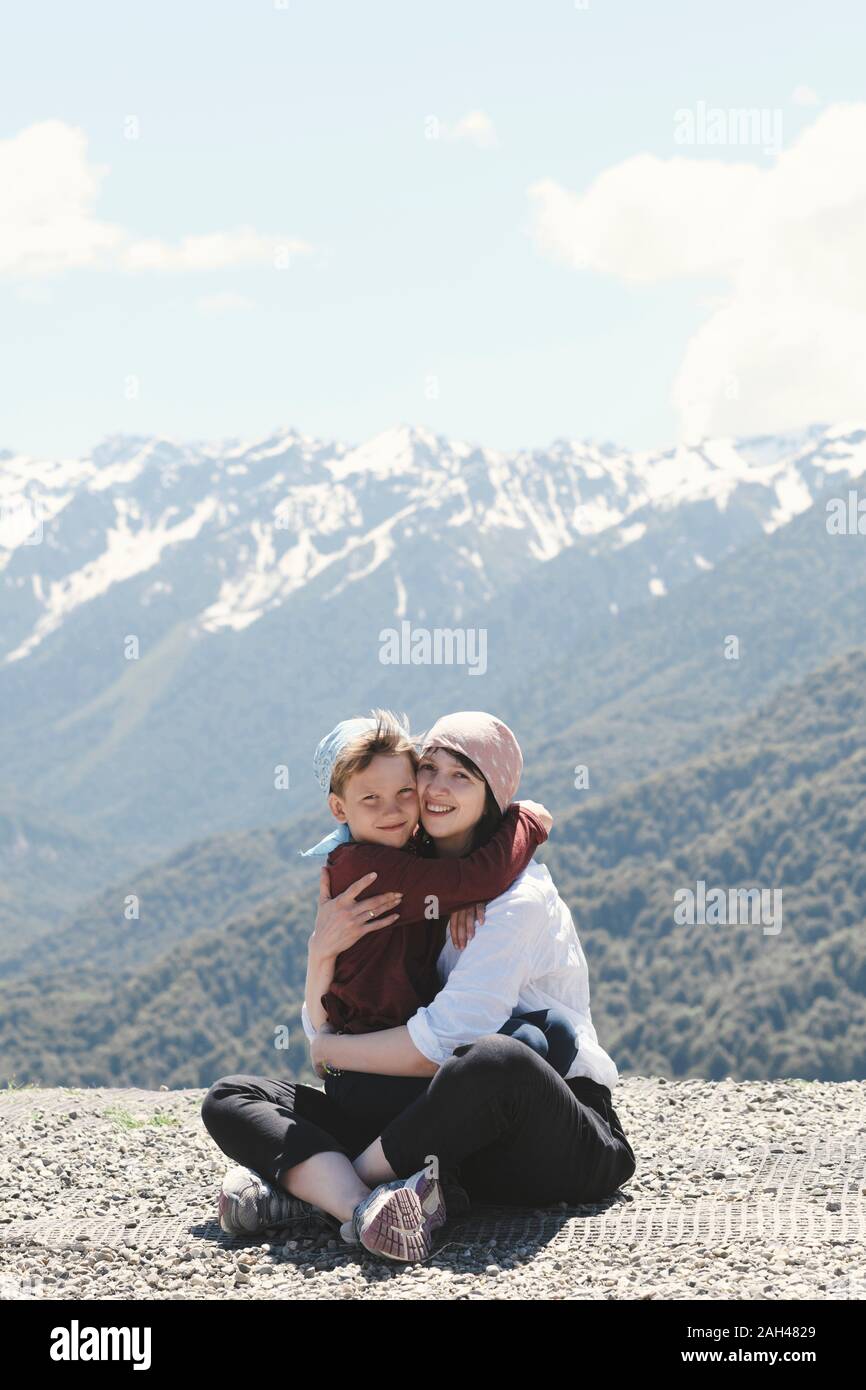 Mother hugging her son in the mountains, Sochi, Russia Stock Photo