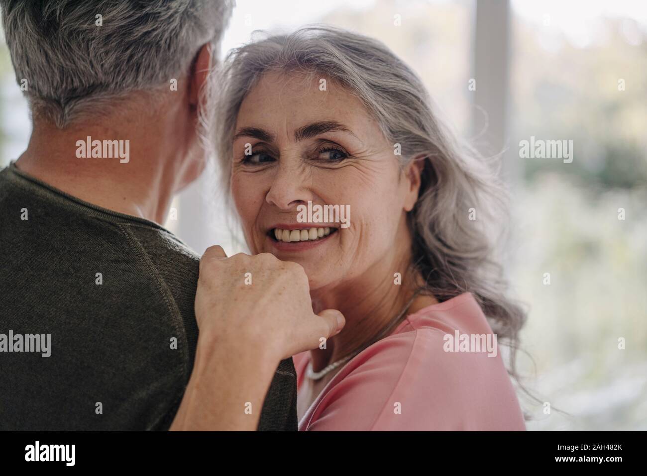 Portrait of smiling mature woman with her husband at home Stock Photo