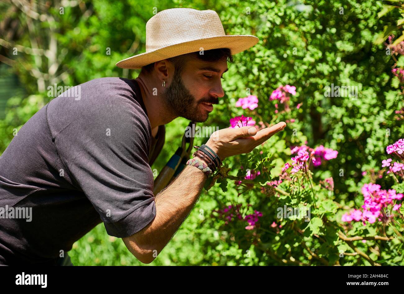 Man smelling flowers in garden Stock Photo