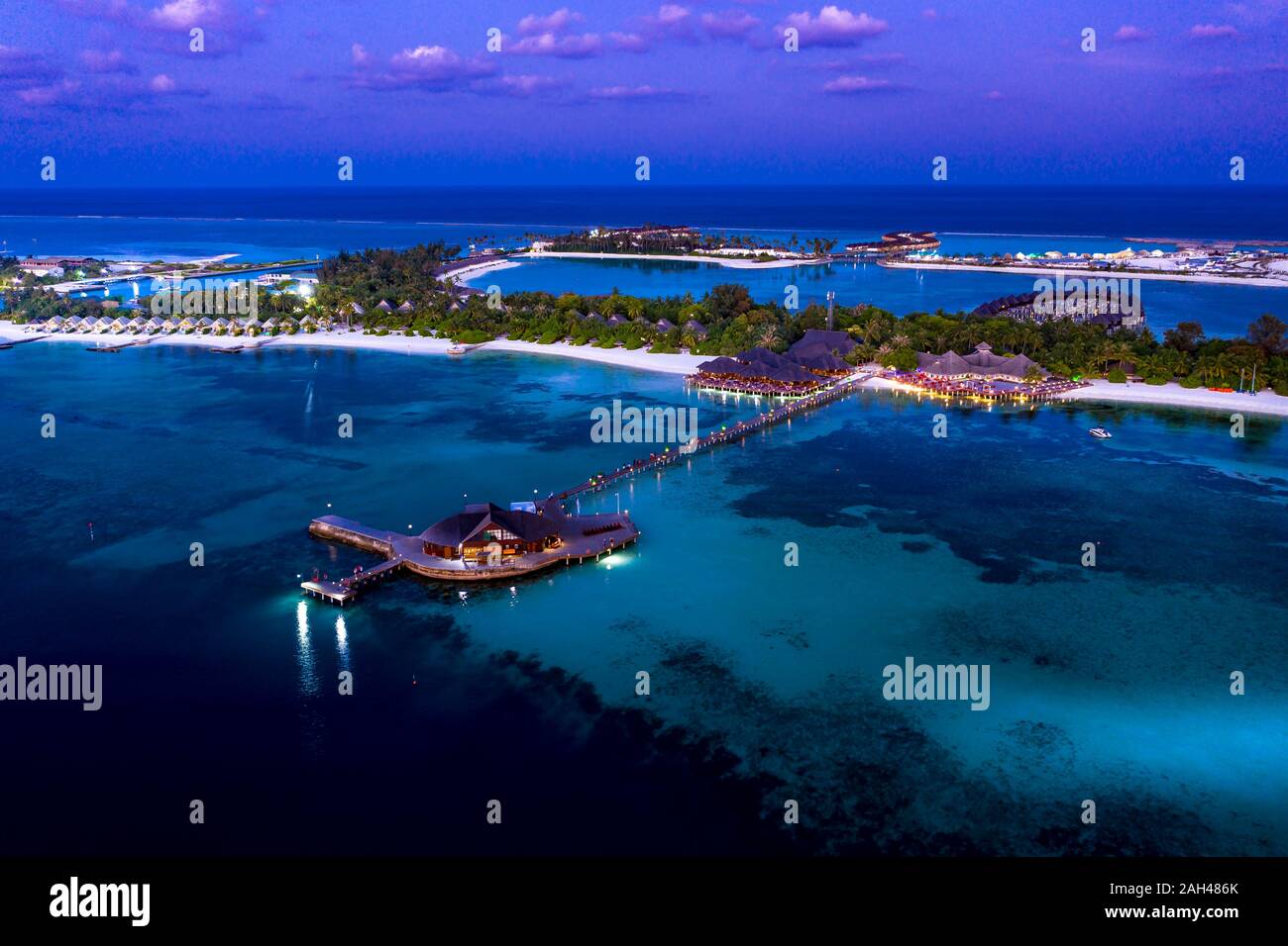 Maldives, Olhuveli, Aerial view of coastal tourist resort on South Male Atoll at dusk Stock Photo