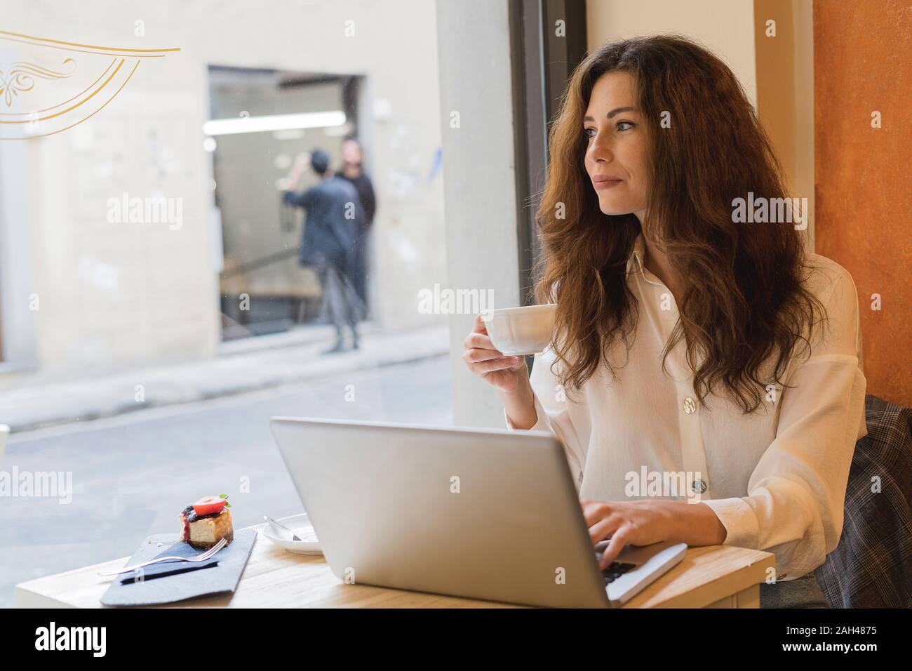 Young woman with laptop in a cafe Stock Photo - Alamy