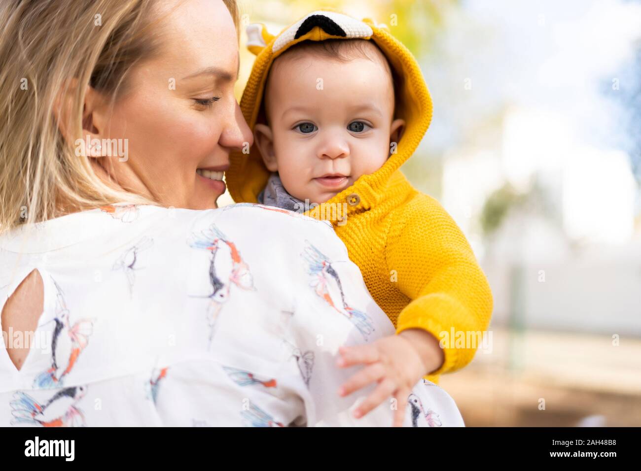 Happy mother carrying baby boy in a park Stock Photo Alamy
