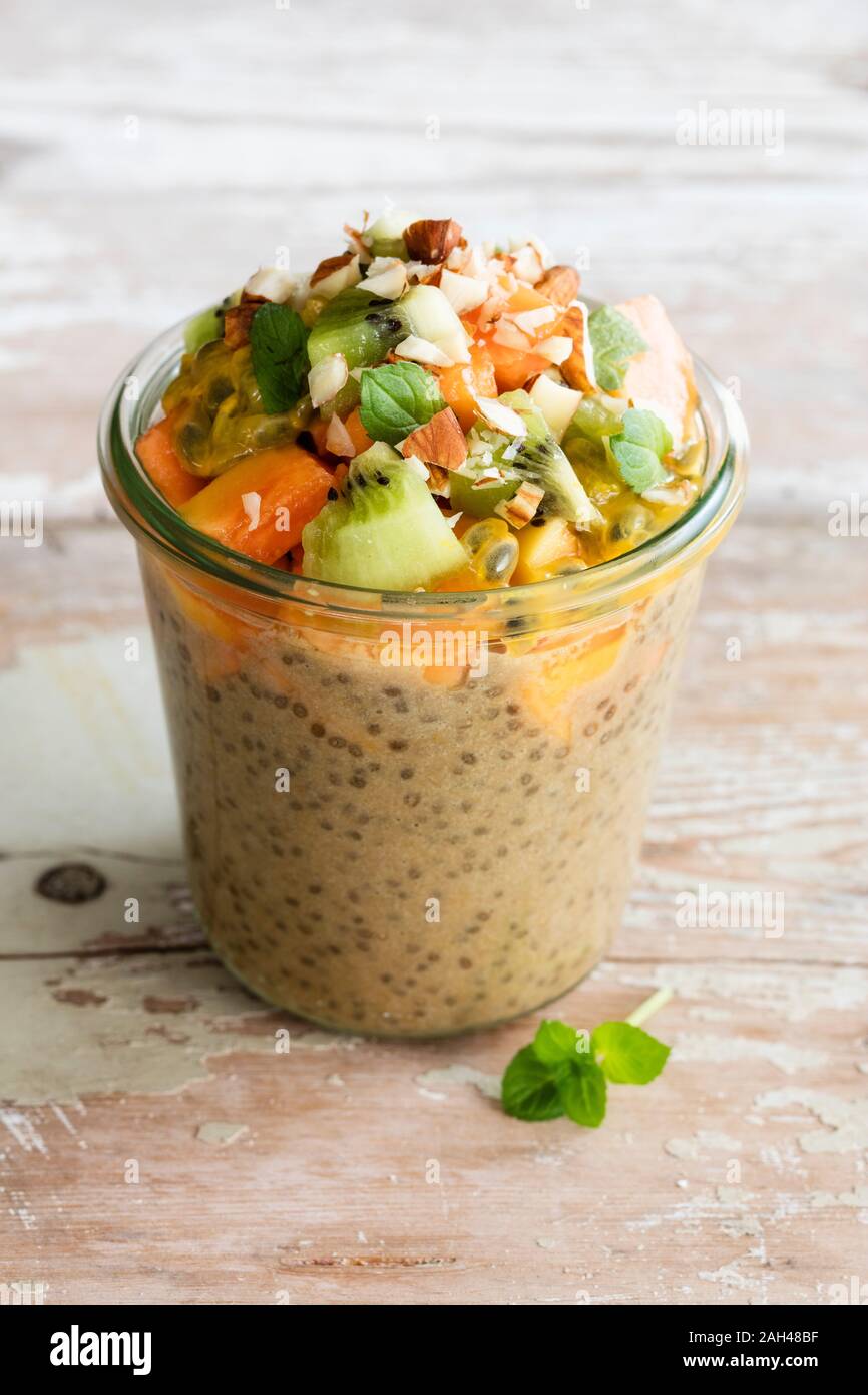 Jar of vegan pudding with chia, almond milk, persimmon, kiwi fruit
