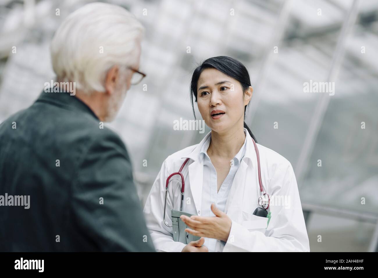 Female doctor talking to senior man Stock Photo