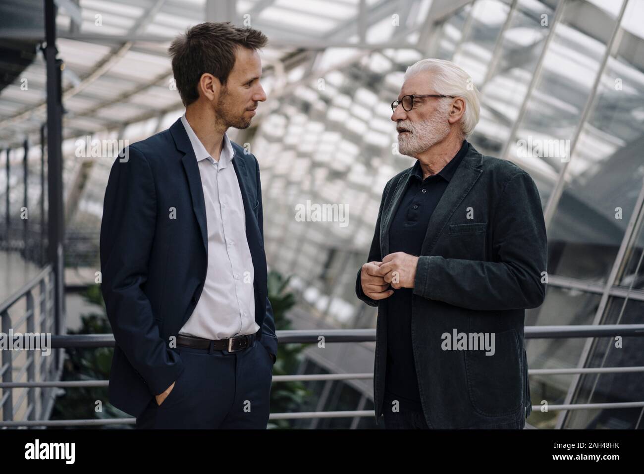 Two businessmen talking in modern office building Stock Photo