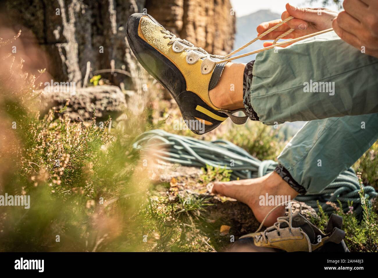 Woman preparing to climb, tying climbing shoe Stock Photo Alamy