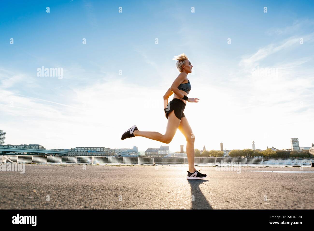 Blonde woman jogging in Cologne, Germany Stock Photo