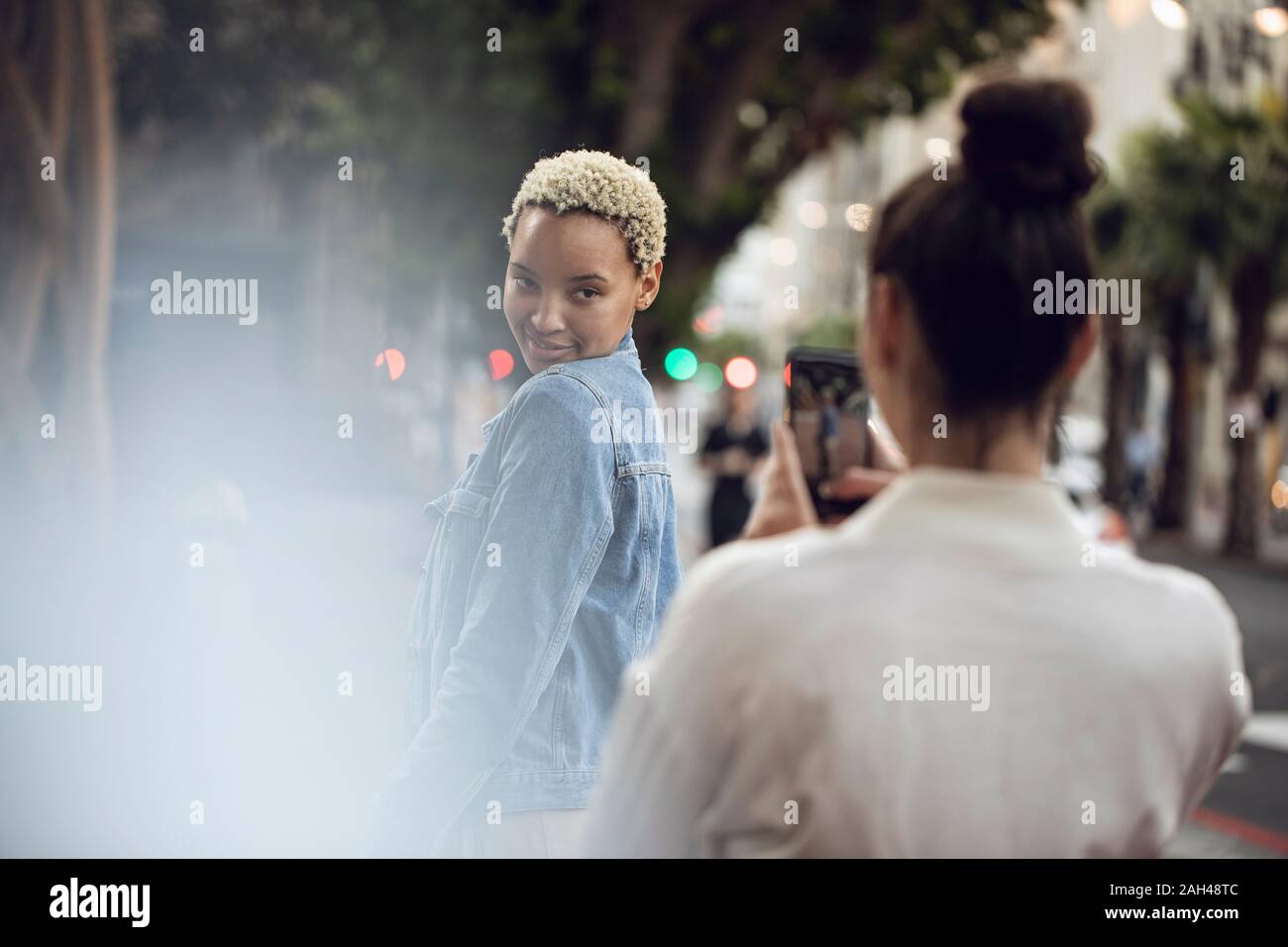 Young woman posing for a smartphone picture in the city Stock Photo