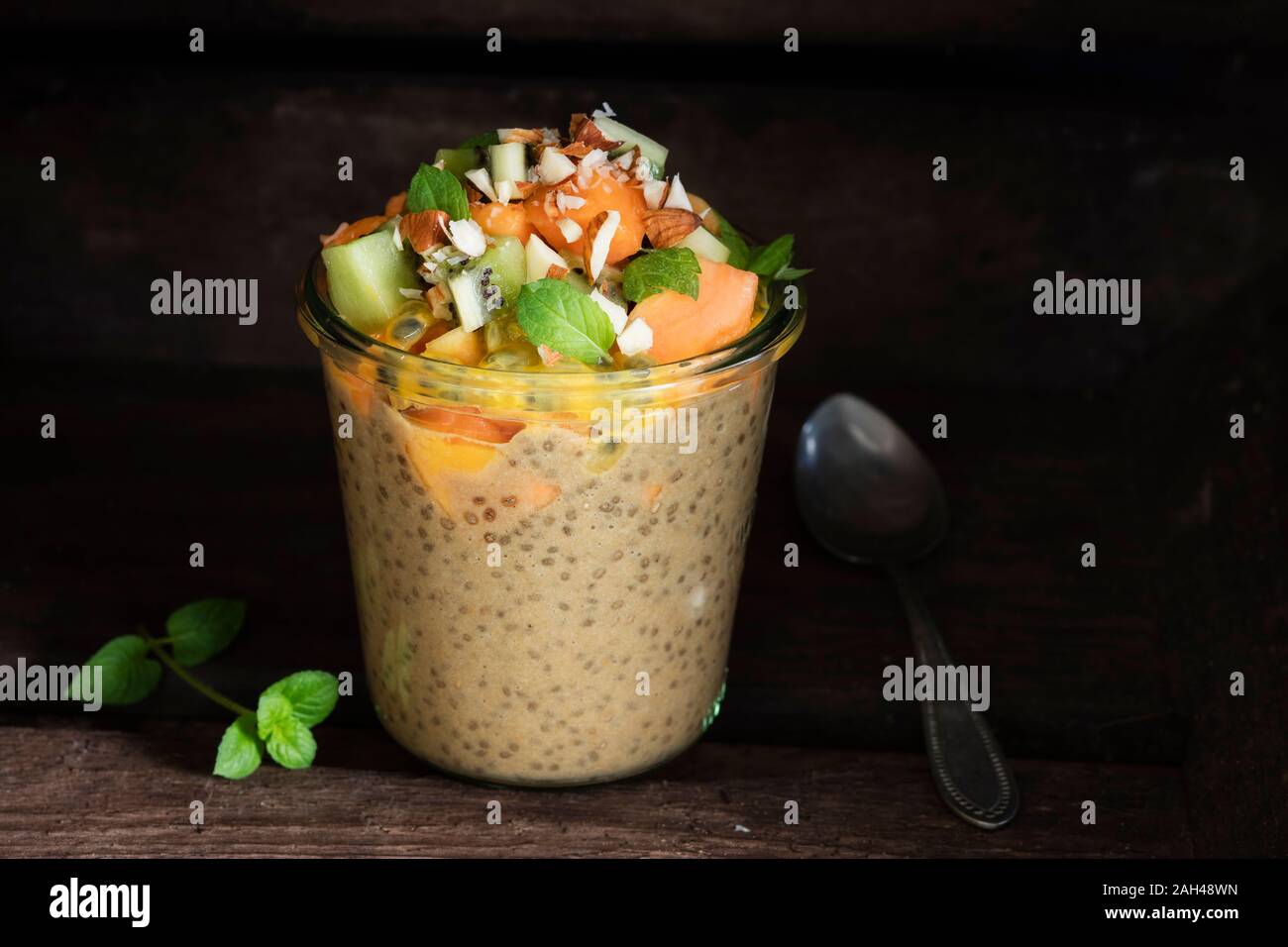 Jar of vegan pudding with chia, almond milk, persimmon, kiwi fruit